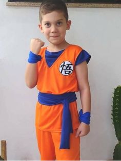 a young boy dressed in an orange and blue dragon ball outfit posing for the camera