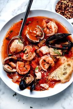 a bowl of seafood soup with bread on the side