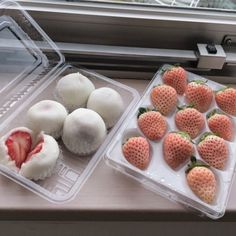 some strawberries are sitting in plastic containers on a window sill next to other foods