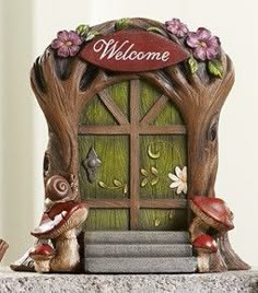 a welcome sign with two little gnomes sitting in front of the entrance to a door