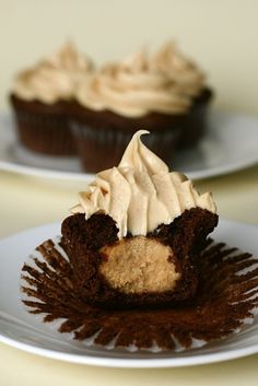 two cupcakes with frosting on white plates