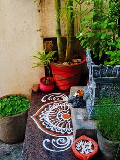 some potted plants are sitting on a table with an intricately designed design painted on it