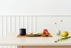 a wooden table topped with plates and vases