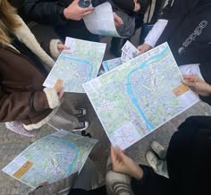 several people are holding maps and looking at them