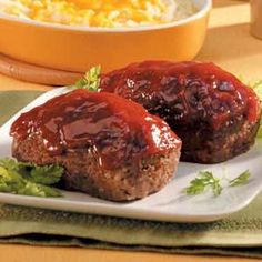 two meatballs covered in ketchup on a plate