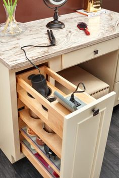 an open drawer in a kitchen with hairdryer and other items on the counter