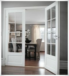 an open door leading to a dining room with chairs and a table in front of it