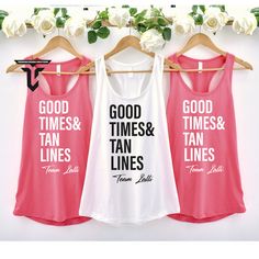 three women's tank tops hanging on a rack with white roses in the background