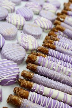 purple and white decorated cookies lined up on a table