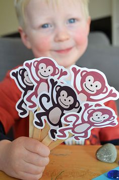 a young boy holding up stickers with monkeys on them