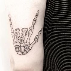 a black and white photo of a skeleton hand tattoo on the right arm, with bones in it