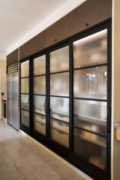 a kitchen with glass doors and cabinets in it