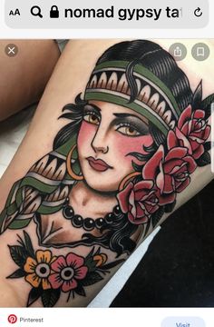 a woman's leg with tattoos on it and flowers in her hair is shown