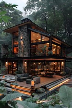 a large house with lots of windows and lights on it's sides in the woods