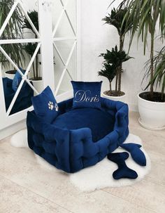 a blue chair with a pillow on it in front of a mirror and potted plant