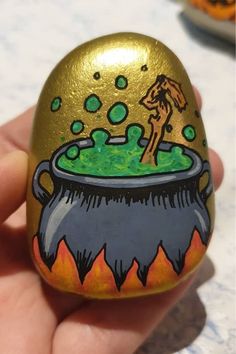 a hand painted gold egg with an image of a man in a cauldster