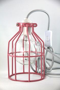 a light bulb in a cage on a white background next to a plugged outlet