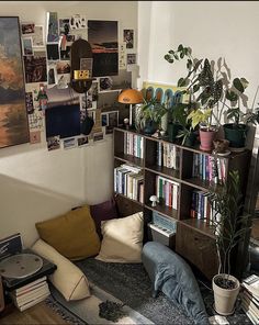 a living room filled with lots of books and plants