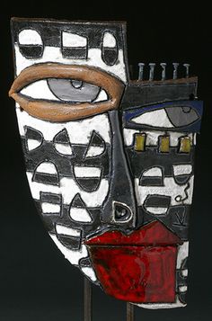 an artistic mask is displayed on a black background with red and white accents, including the eye