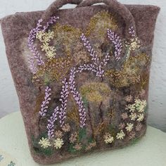 This handmade grey large shoulder bag was created wett felting metod. Felted bag has zipper closure.  An casual felt tote handbag with an interesting and unusual style, with elements of embroidery. Embroidered bag has flowers decor of cotton multicolor fibers. Inside of everyday bag is lining from fabric and pocket for a mobile phone. A bag has felted handles. Large tote wool bag is specifically for all seasons. Handmade from 100% nature merino wool. Measurements aprocsımetly: width:  11.0 inch Felt Handbag, Felted Bag, Felt Tote, Felted Handbags, Wool Bags, Flowers Decor, Embroidered Bag, Large Shoulder Bags, Felt Bag