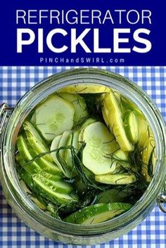 a jar filled with sliced cucumbers on top of a blue and white checkered table