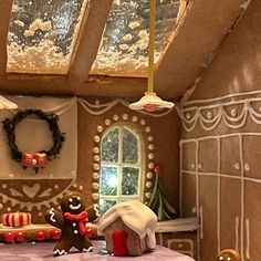 a gingerbread house decorated for christmas with decorations on the table and around the room