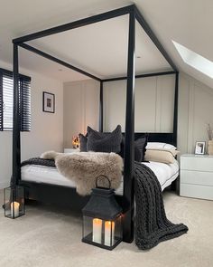 a black and white bedroom with four poster bed