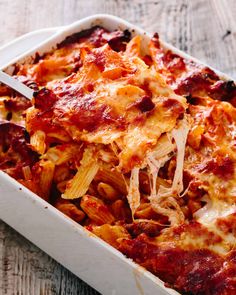 a casserole dish with meat and cheese in it on a wooden table top