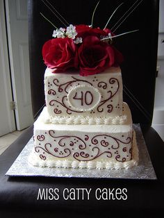 a three tiered cake with red roses on top and the number 40 on it