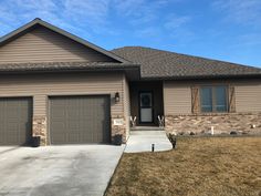 a house that has two garages on the front and one is gray with brown trim