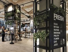 the interior of a restaurant with plants growing on the wall and people sitting at tables