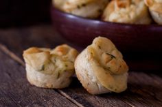 some food is sitting in a bowl on a wooden table next to a bowl of biscuits