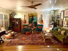 a living room filled with lots of furniture and decor on top of a hard wood floor