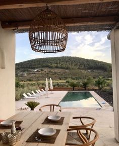 an outdoor dining area with wooden table and chairs