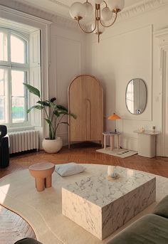 a living room filled with furniture and a large mirror on the wall next to a window