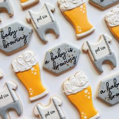 baby is brewing decorated cookies arranged on a white table with yellow and gray frosting