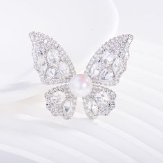 Embrace elegance with our Butterfly Brooch, featuring a radiant 8-9mm freshwater pearl nestled among sparkling cubic zirconia. Available in gold and silver finishes, this exquisite piece adds a touch of sophistication to any outfit. A perfect gift to symbolize transformation and beauty Material: Gold plated on brass, cubic zirconia, and freshwater pearls Pearl Size: 8-9mm Note: Our jewelry is handmade. Naturally formed shapes of freshwater baroque pearls may vary. The actual product may be sligh White Diamond Wedding Brooches, Luxury Diamond White Brooches For Wedding, Elegant Diamond White Brooches For Wedding, Elegant Diamond White Wedding Brooches, Elegant Brooch With Diamond Accents As Gift, Elegant Diamond Accented Brooch Gift, Elegant Diamond Accented Brooches As Gifts, Elegant Diamond Accents Brooch For Gift, Elegant Diamond Accented Brooches For Gifts