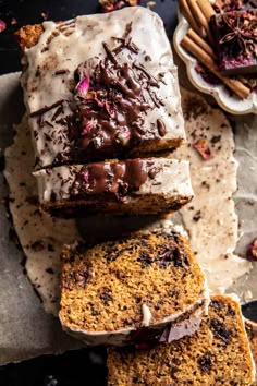 slices of cake with frosting and chocolate toppings sitting on top of each other