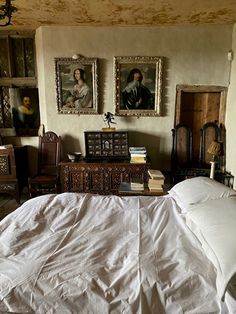 a bed in a room with paintings on the wall