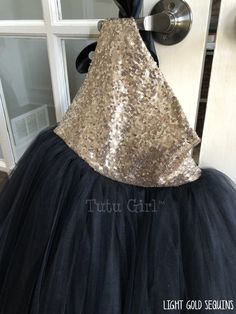 "Such a striking tulle dress! It's created in our true gold sequins with a black ribbon tie and black tulle skirt. The dress opens and closes at the top of the right shoulder. The bodice is fully lined. We offer the following sequin colors: gold, light gold, rose gold, blush pink, champagne, silver, white and black WANT A SEWN IN SLIP TO LINE THE TUTU? https://www.etsy.com/listing/125566641/add-a-slip-to-the-tutu-dress-sewn-in At checkout, please give us the following information: HOW TO ORDER: Glamorous Gold Tulle Dresses, Gold Glitter Tulle Dress For Dress-up, Elegant Fitted Gold Tutu Dress, Black Sequined Celebration Dress, Black Sequined Dress For Celebration, Gold Tutu Dress With Sequins For Dress-up, Gold Fitted Tutu Dress For Dress-up, Gold Sequined Tutu Dress For Dress-up, Gold Tulle Tutu Dress For Dress-up