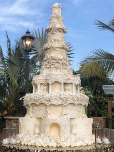 a large white wedding cake sitting on top of a table next to a lamp post