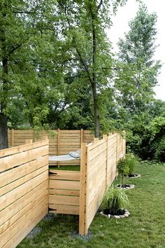 a wooden fence in the middle of a grassy area