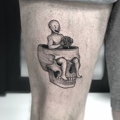 a man's leg with a skull and a human head on it, in black ink