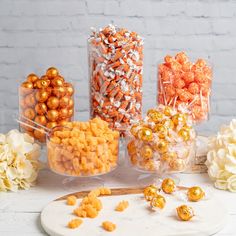 there are many different types of candies on the table with white flowers around them