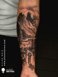 a man's arm with a mountain scene tattoo on it