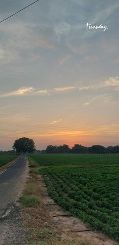 the sun is setting over an open field