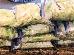 several bags of cabbage sitting on top of a counter