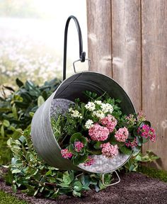 a potted planter with pink and white flowers hanging from it's side