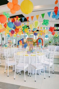 a room filled with tables and chairs covered in balloons