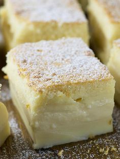 several pieces of cake sitting on top of a metal pan covered in powdered sugar